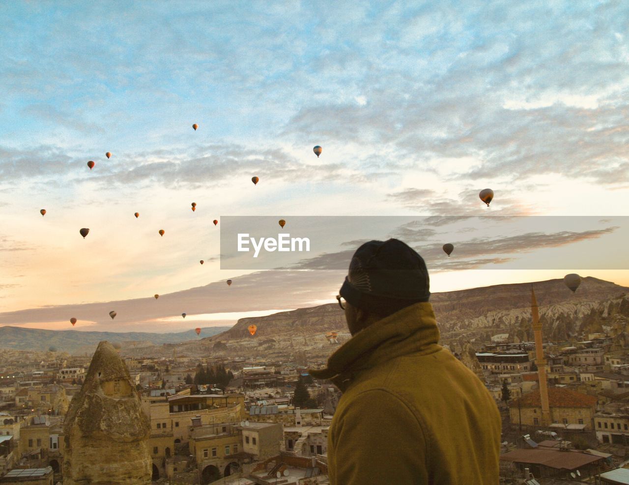 Rear view of man and buildings against sky