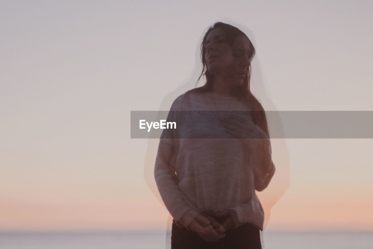 Multiple image of woman standing at beach against sky