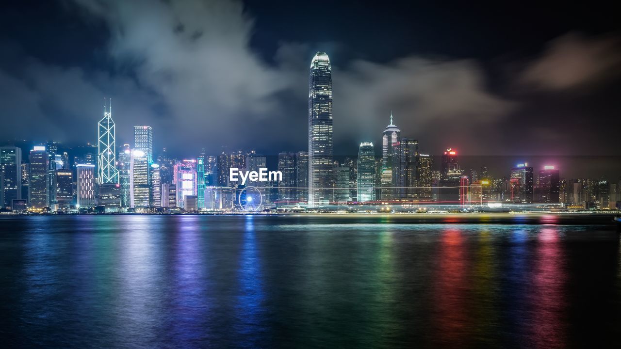 Victoria harbor against illuminated modern buildings