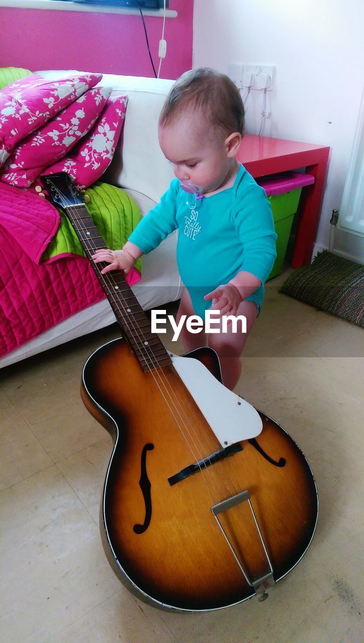 CUTE GIRL PLAYING GUITAR ON THE WALL