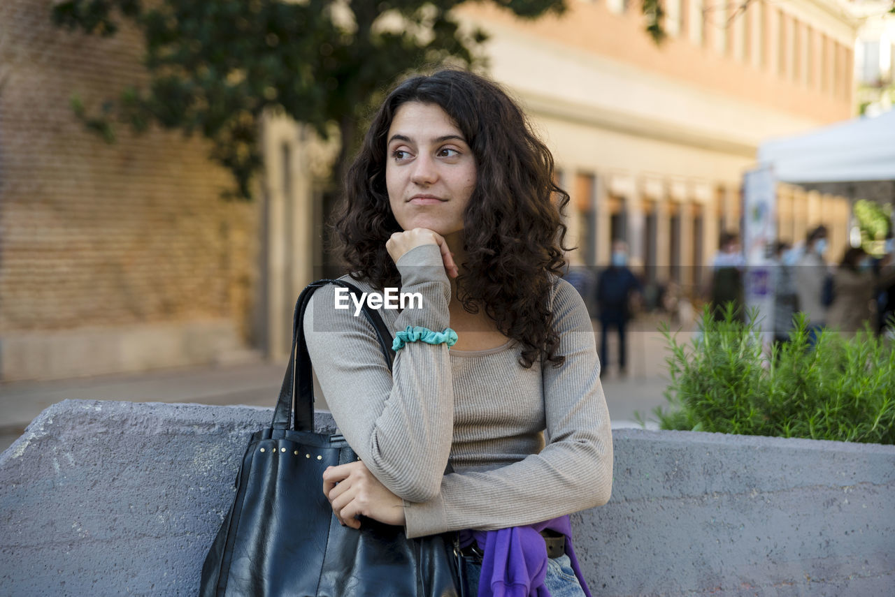 Woman smiling while posing outdoors at the street.