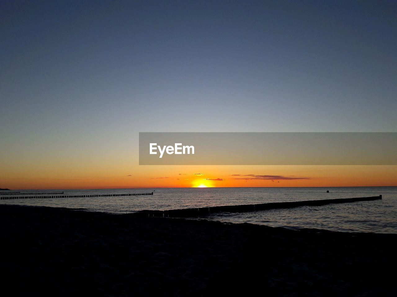 SCENIC VIEW OF BEACH DURING SUNSET