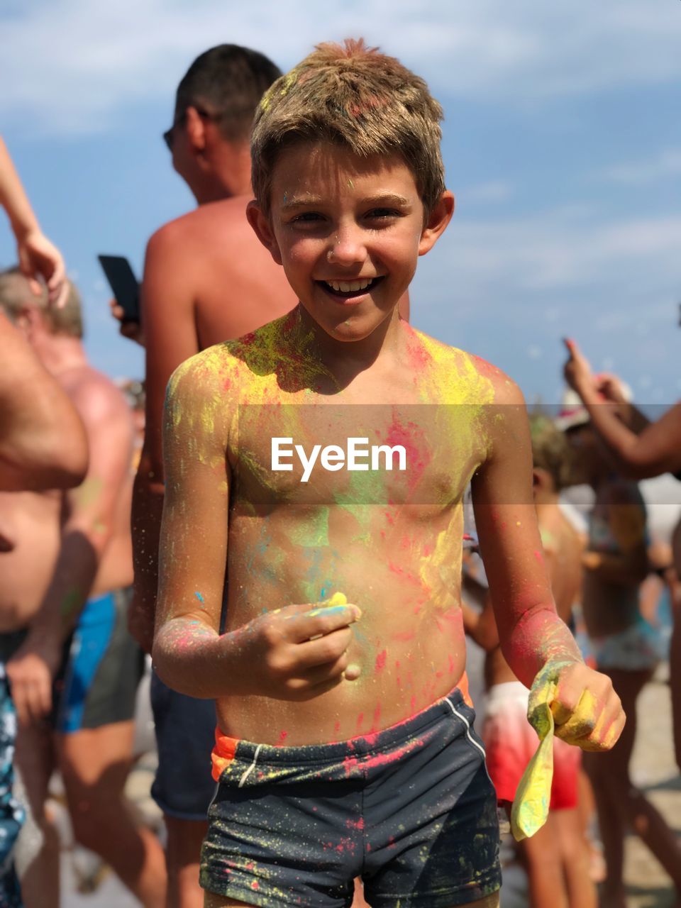 Shirtless boy with powder paint standing outdoors