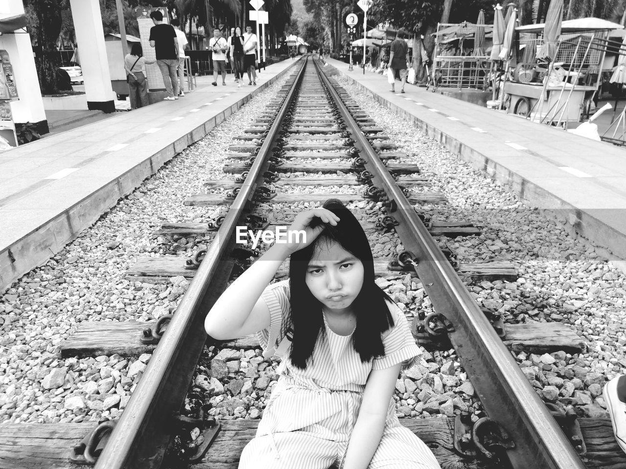 Portrait of woman sitting on railroad track