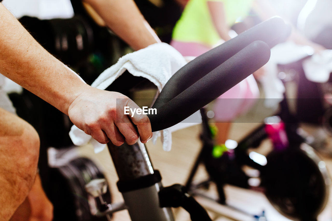 Cropped hands using exercise bike at gym