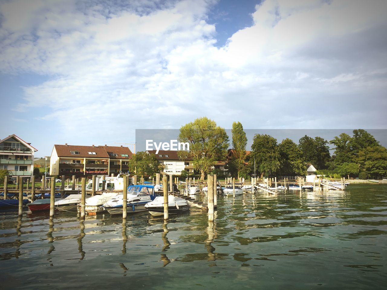 VIEW OF BOATS MOORED IN SEA AGAINST CLOUDY SKY