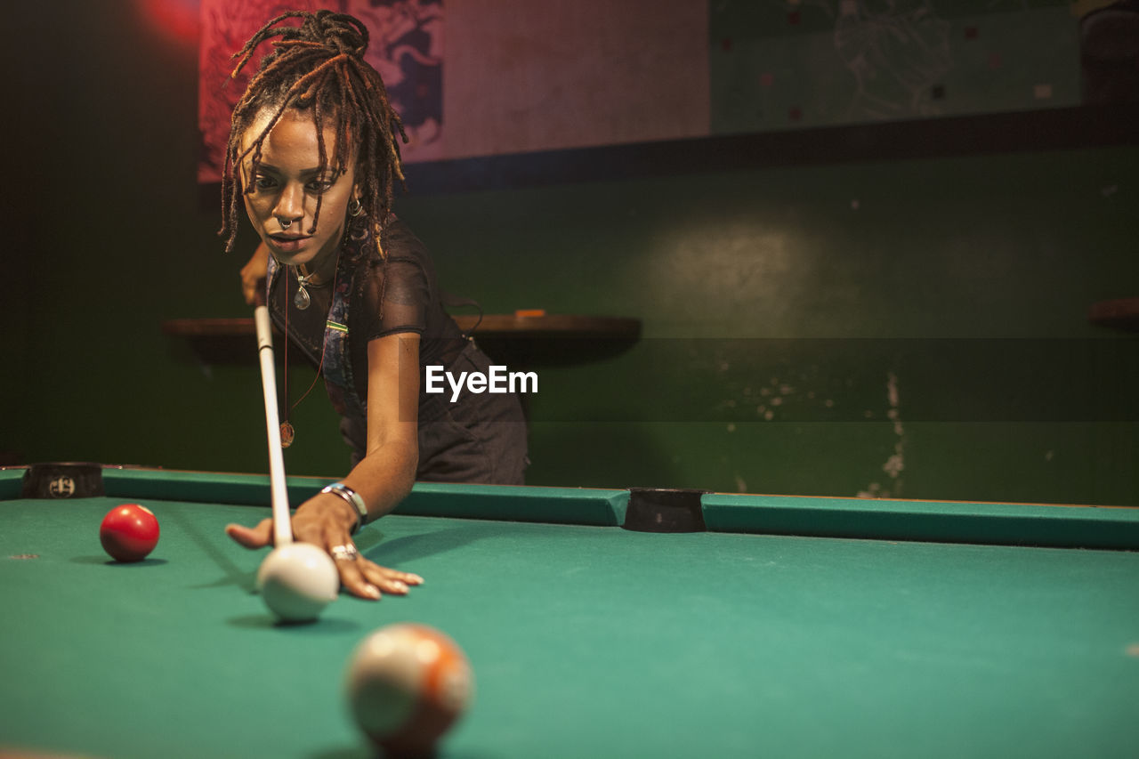 A young woman playing pool.