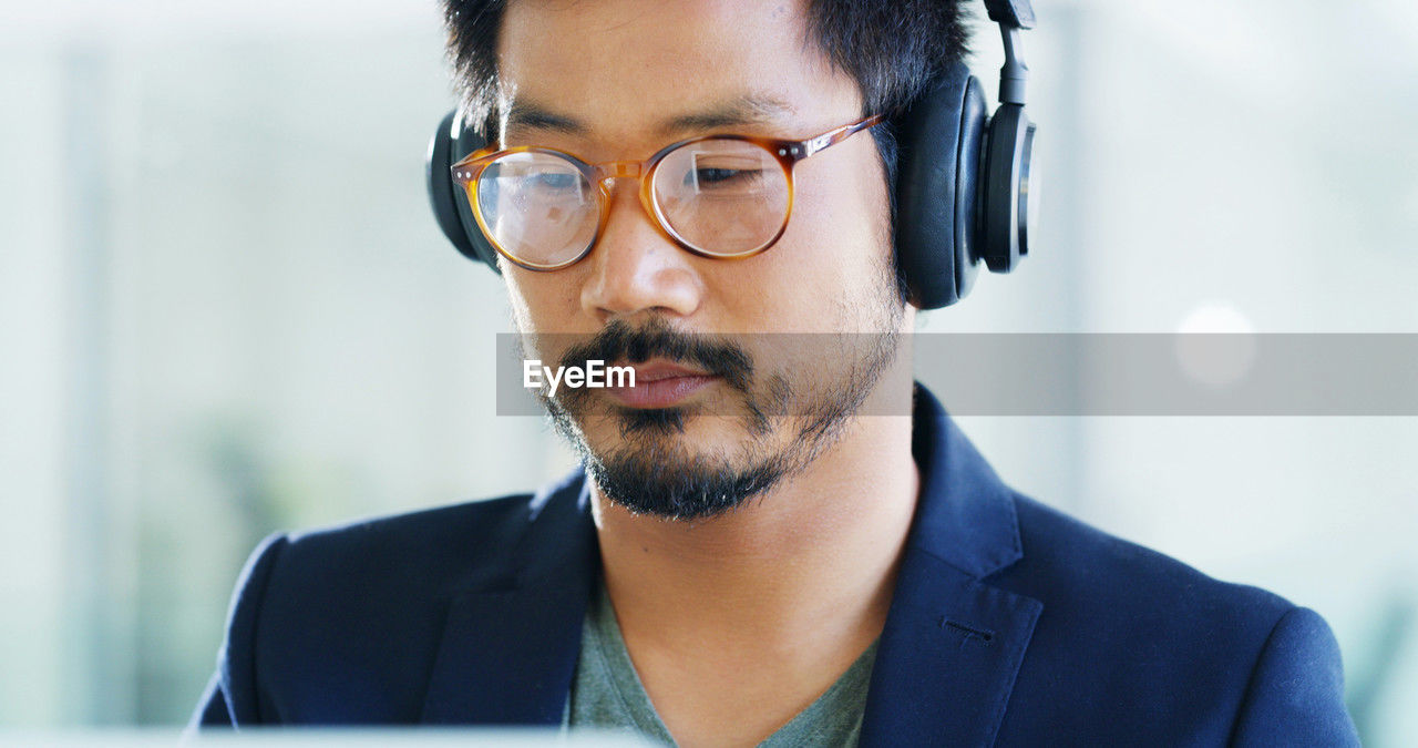 adult, business, headshot, one person, eyeglasses, men, vision care, glasses, technology, office, portrait, businessman, beard, business finance and industry, eyewear, indoors, person, communication, businesswear, facial hair, working, occupation, looking, computer, corporate business, front view, expertise, professional occupation, wireless technology, human face, young adult, listening, black hair, contemplation, close-up, new business, concentration, white-collar worker