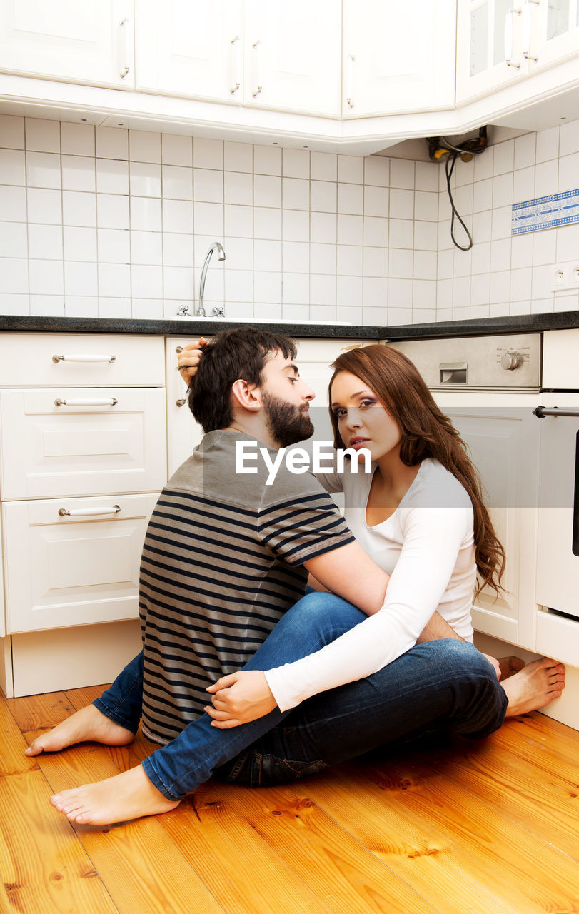 Romantic young couple sitting in kitchen
