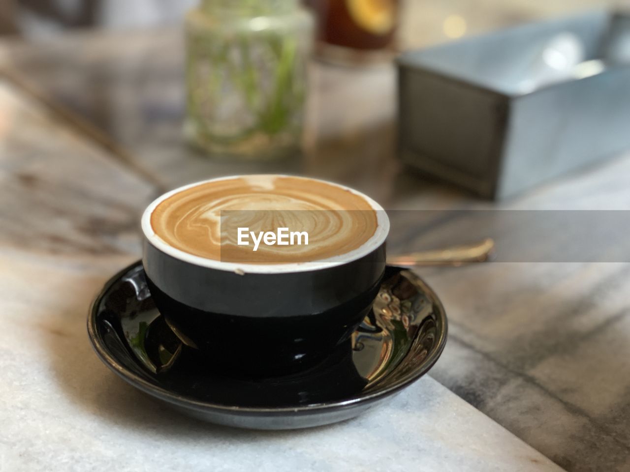 COFFEE CUP ON TABLE AT CAFE