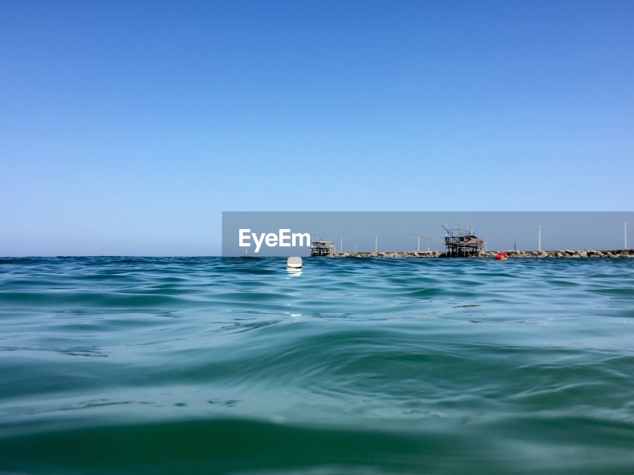 Scenic view of sea against clear blue sky