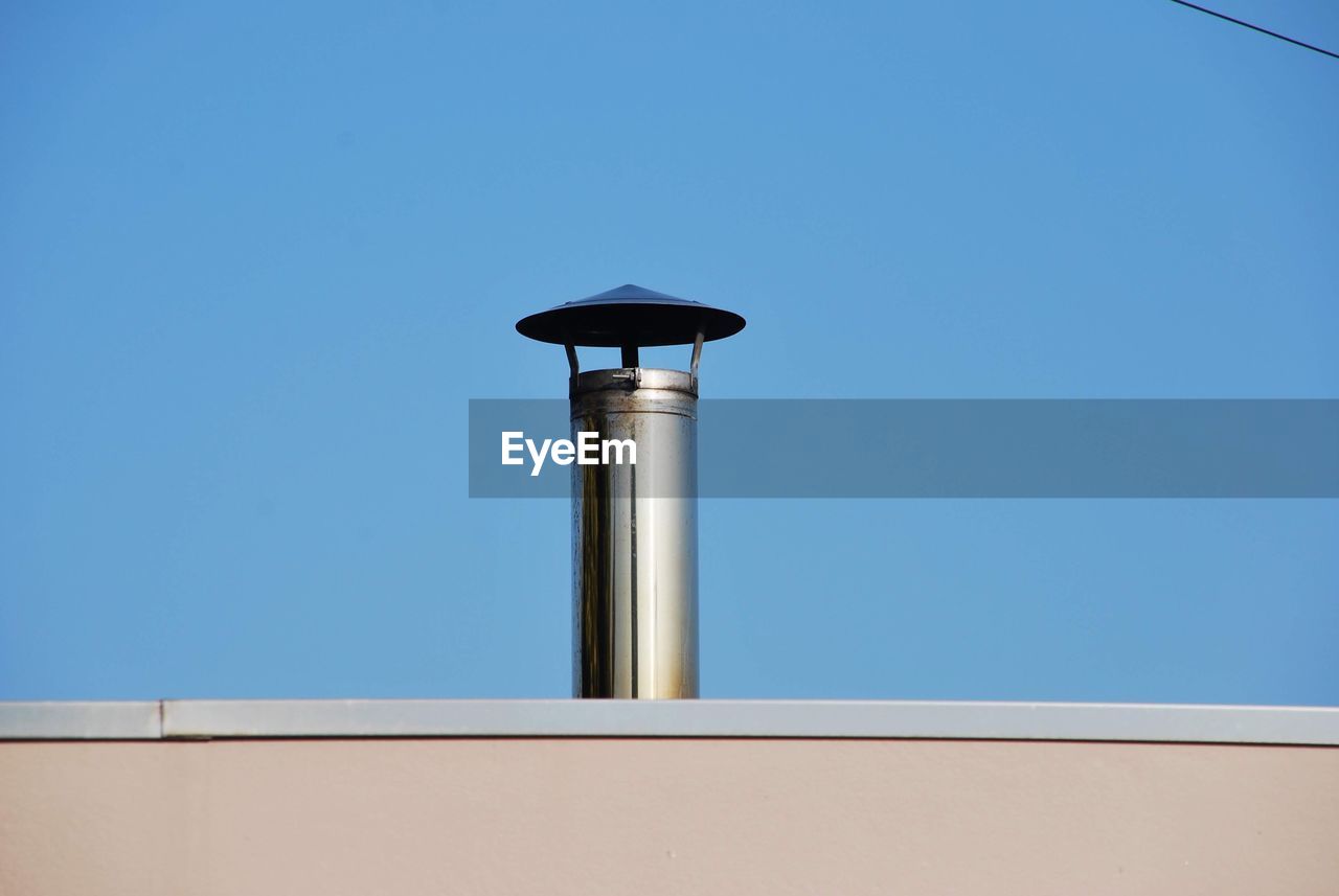 Low angle view of chamine  against clear blue sky
