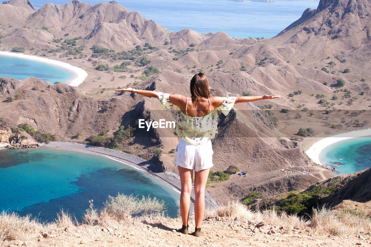 Rear view of woman standing on against mountain