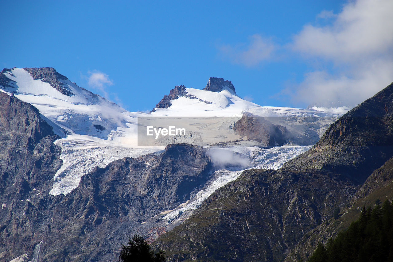 Scenic view of snowcapped gran paradiso massif and glaciers against sky, as seen from cogne in italy