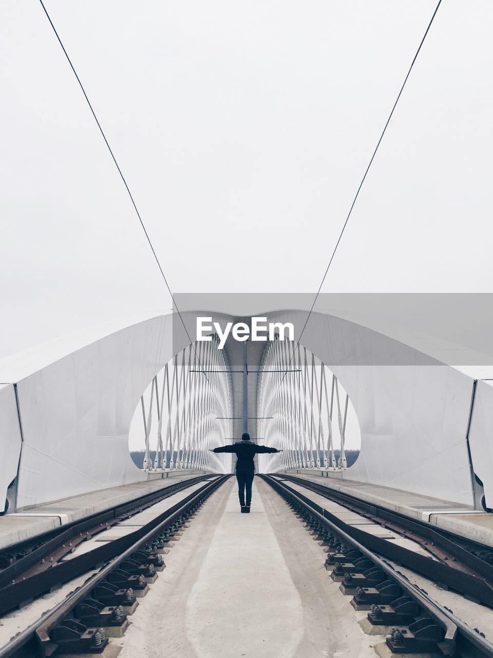 Rear view of man standing on railway track