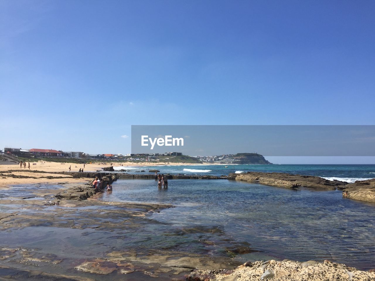 PEOPLE ON BEACH AGAINST CLEAR BLUE SKY