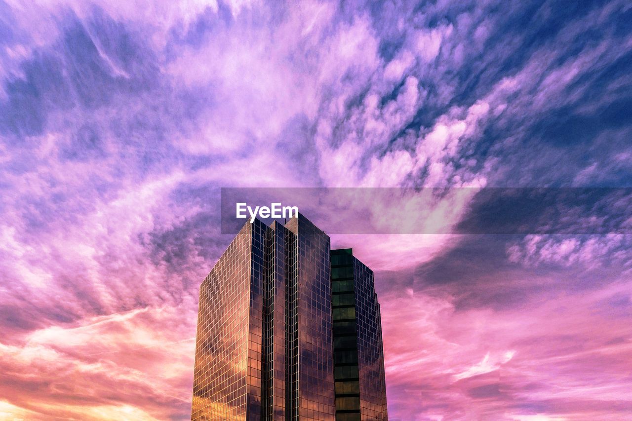 Low angle view of modern building against dramatic sky