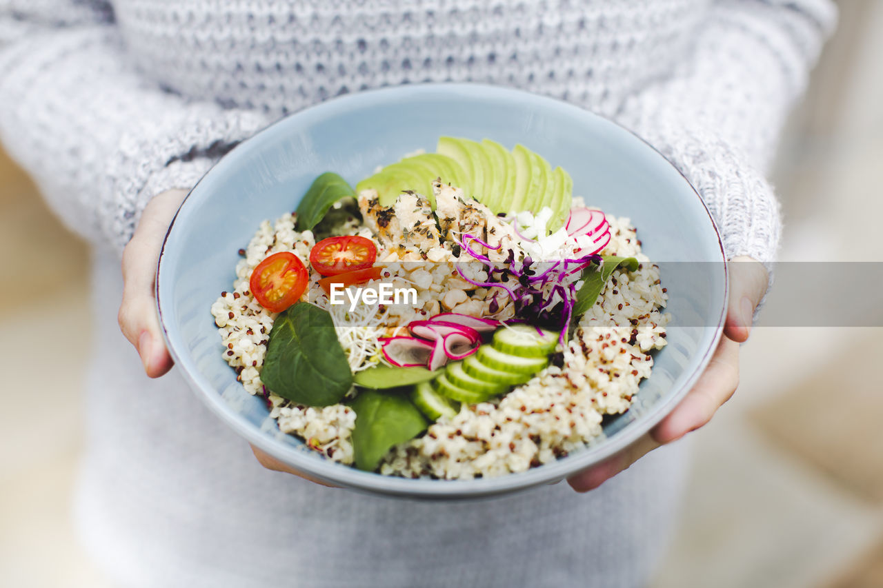 Midsection of woman holding salad bowl