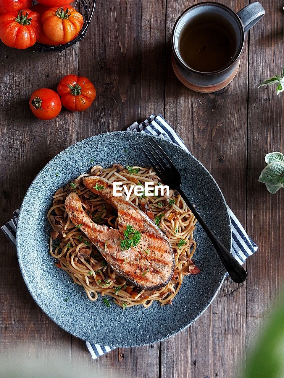 High angle view of spaghetti and grilled salmon served on table