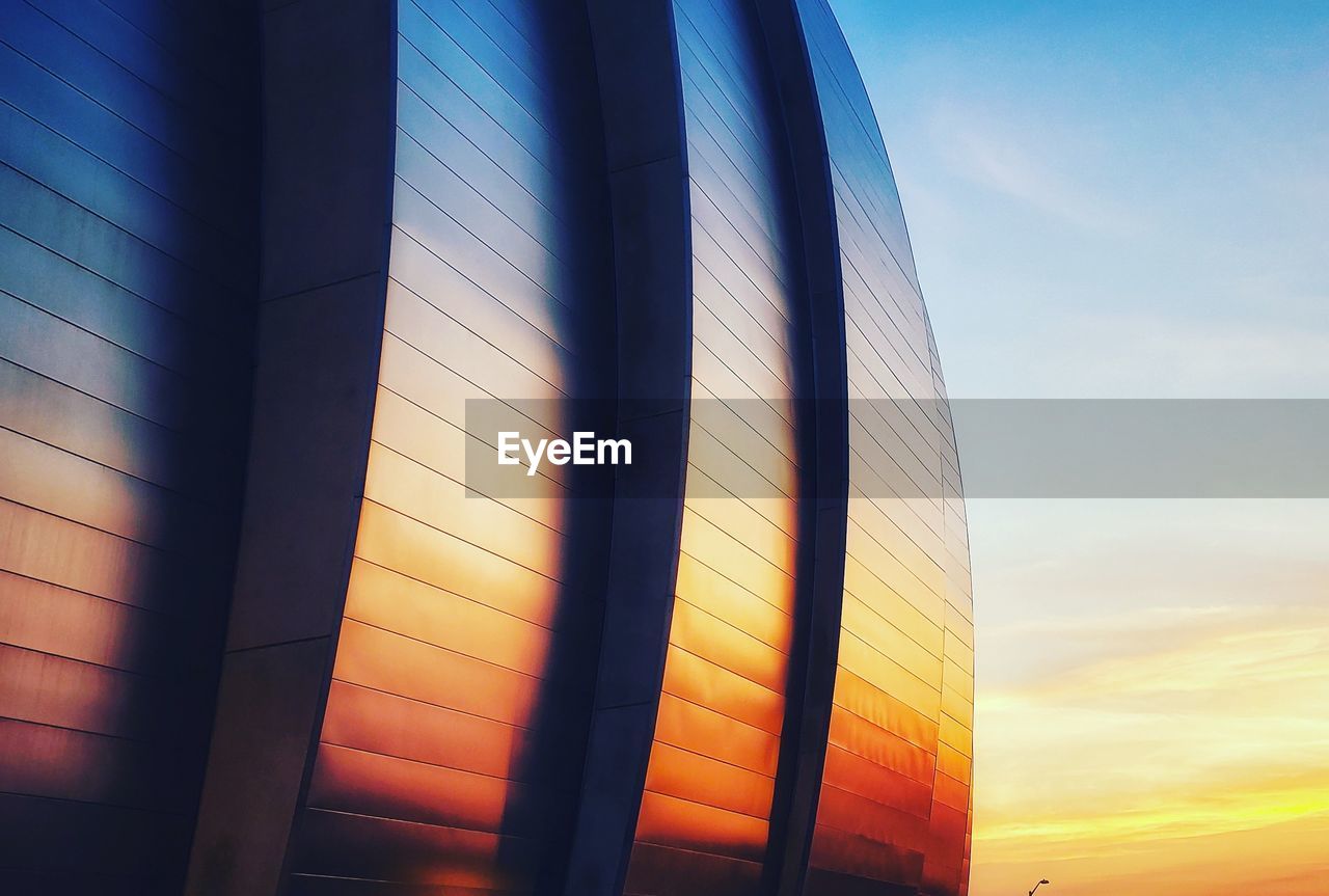 Low angle view of glass building against sky