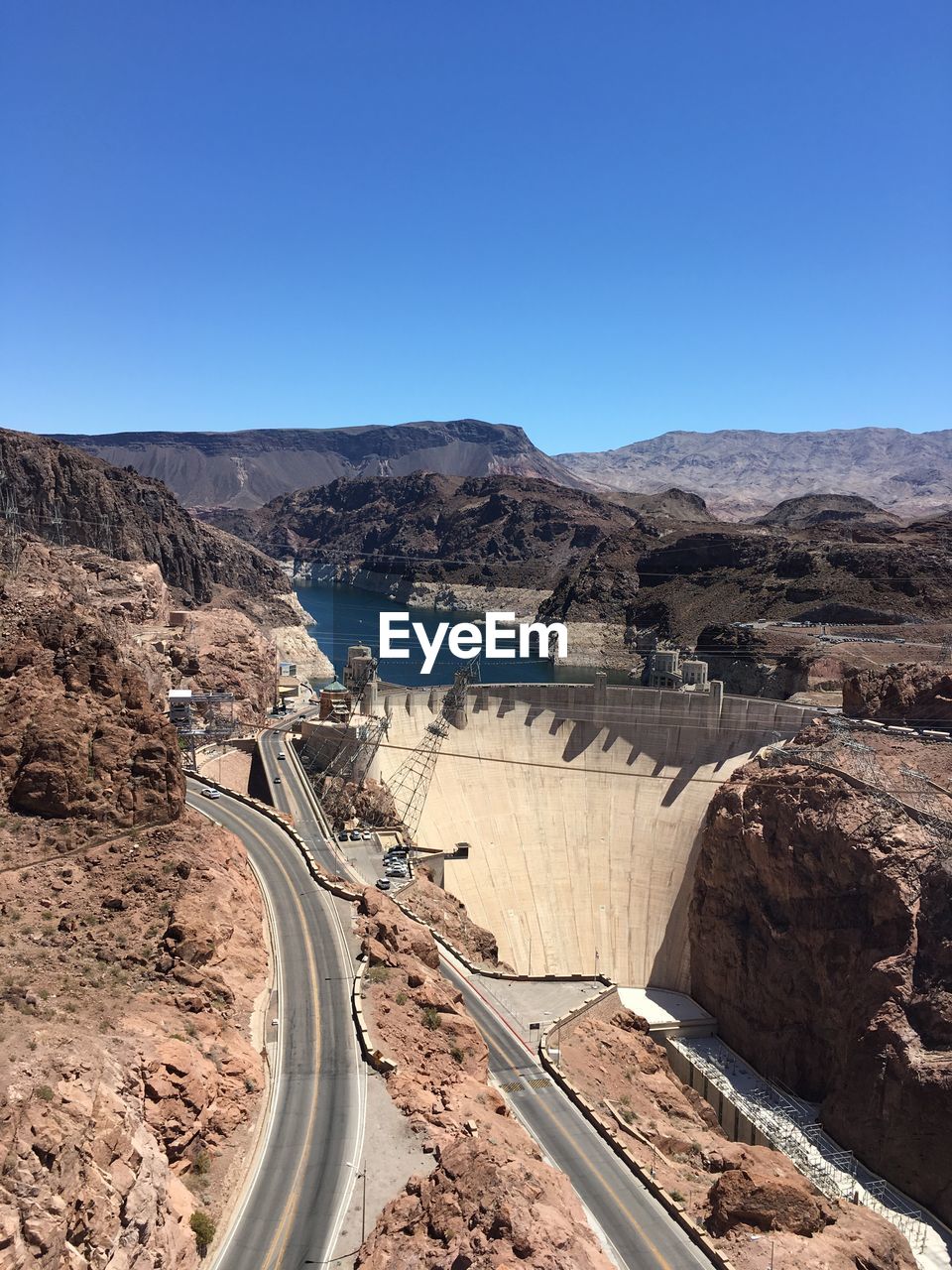 Scenic view of dam and mountains against clear sky