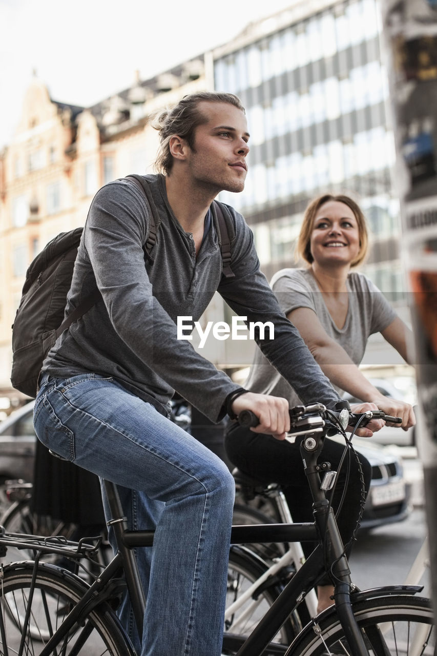 Man and woman cycling on city street