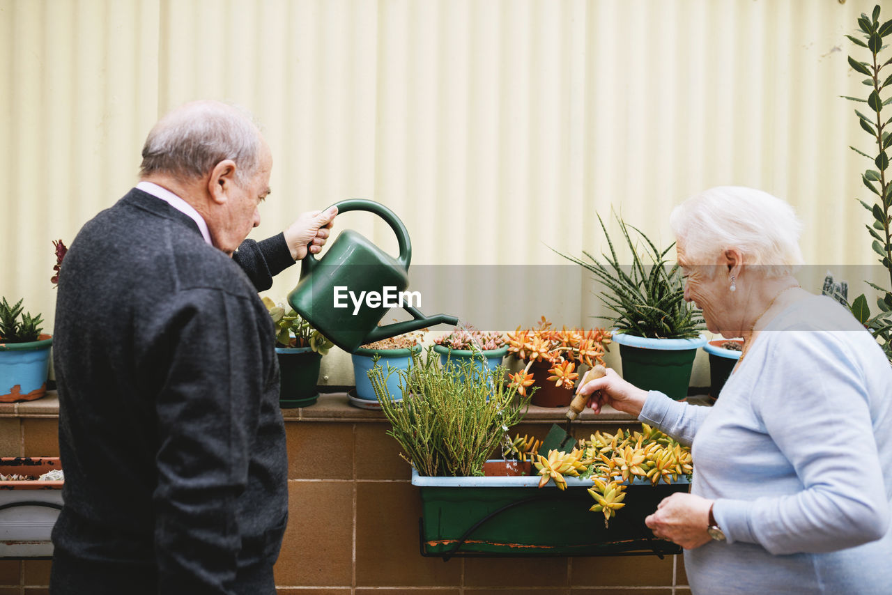 Senior couple gardening on balcony