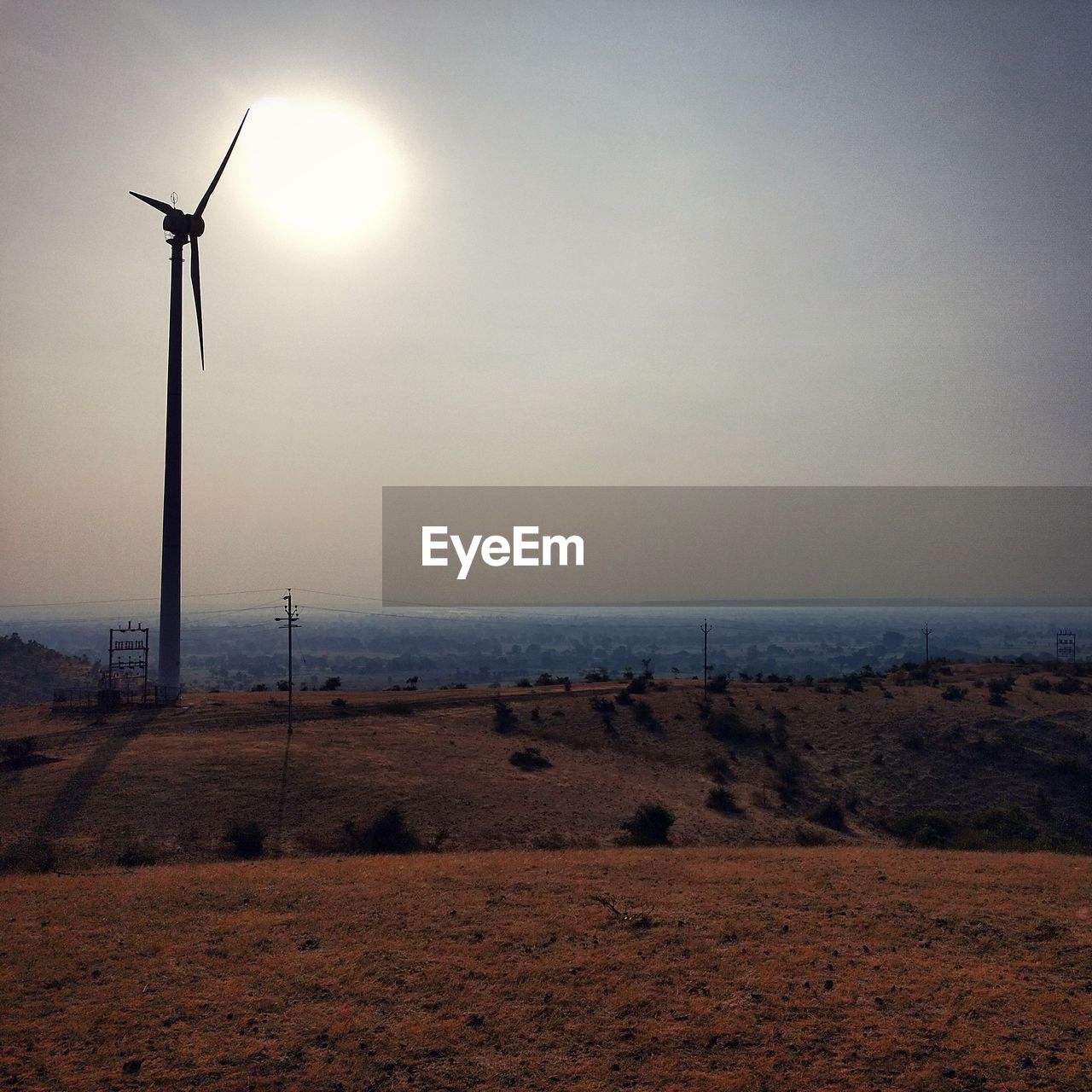 Wind turbines on land against sky