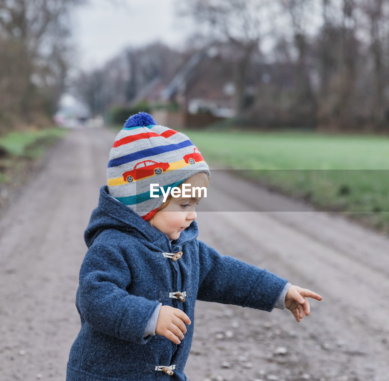 Rear view of boy looking at park during winter