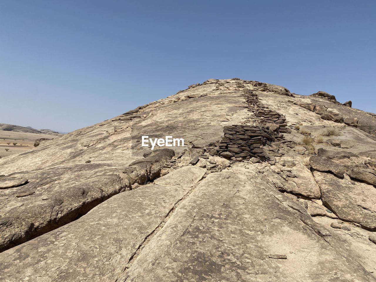 LOW ANGLE VIEW OF ROCKS AGAINST CLEAR BLUE SKY