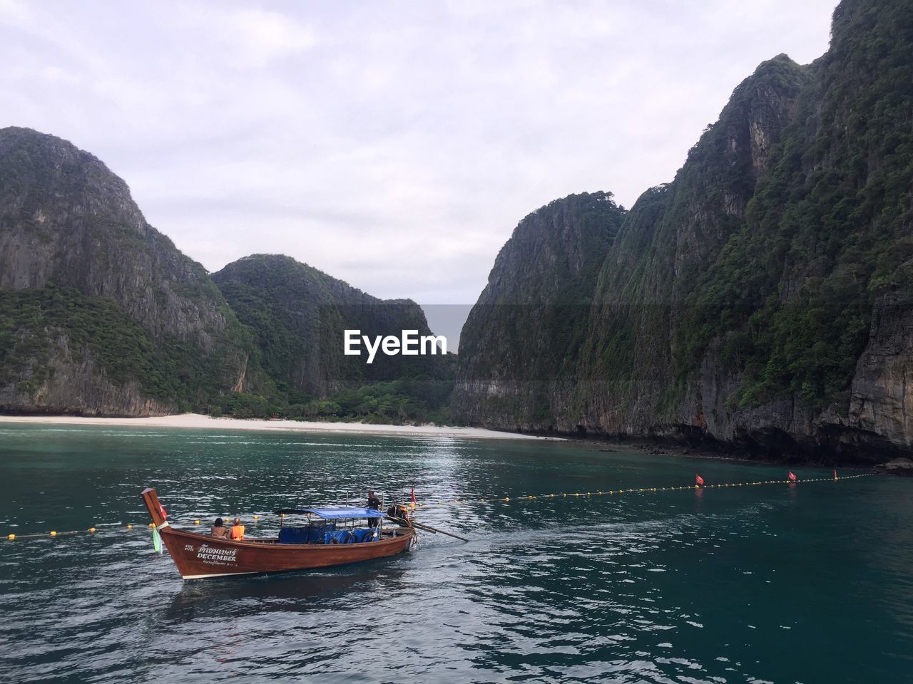 BOAT ON SEA AGAINST MOUNTAINS