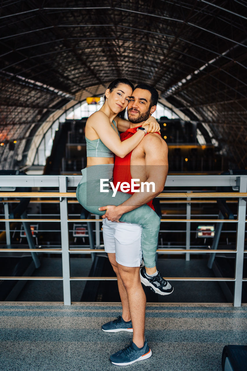 Portrait of young couple in love holding each other in gym