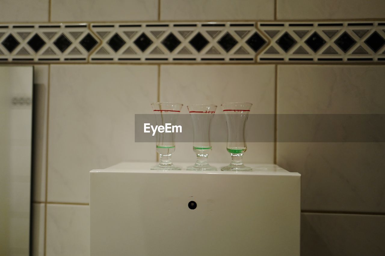 Glasses on table against wall at home