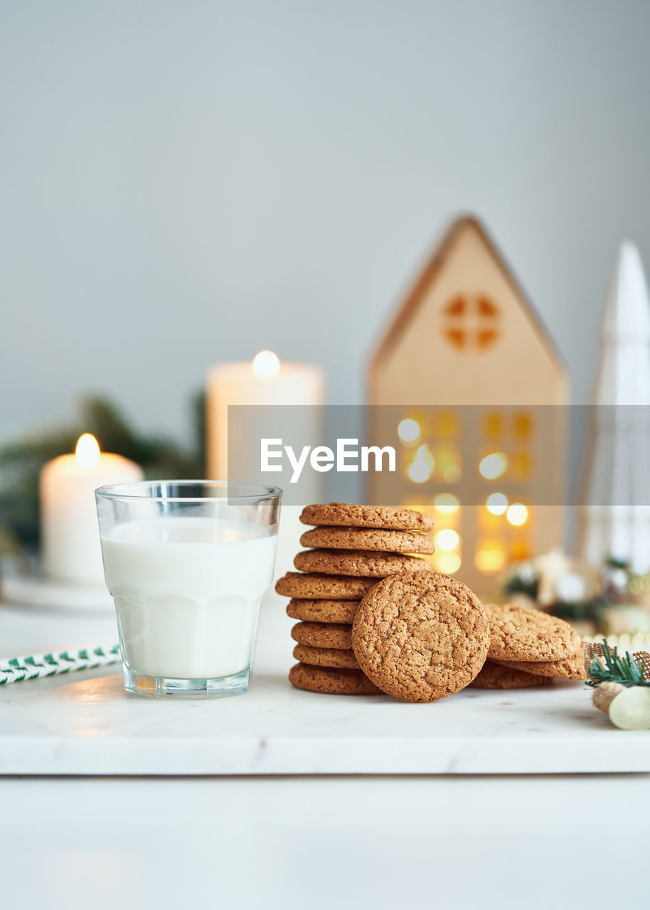 Christmas background with oatmeal and ginger chip cookies, glass with milk. cozy evening at home