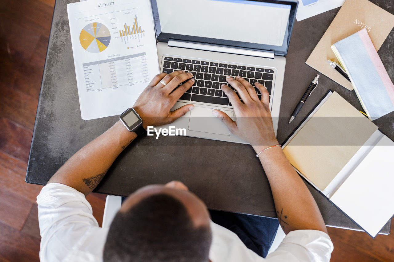 Man using laptop at desk in home office