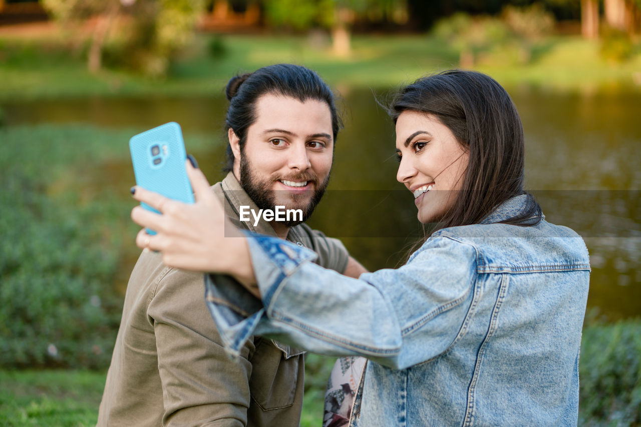 portrait of smiling young woman using mobile phone