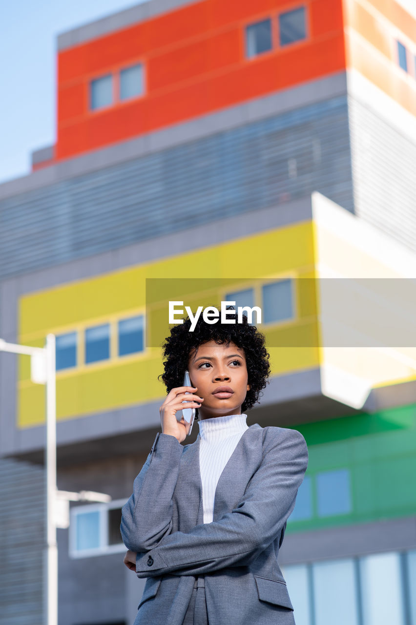 portrait of woman standing against building