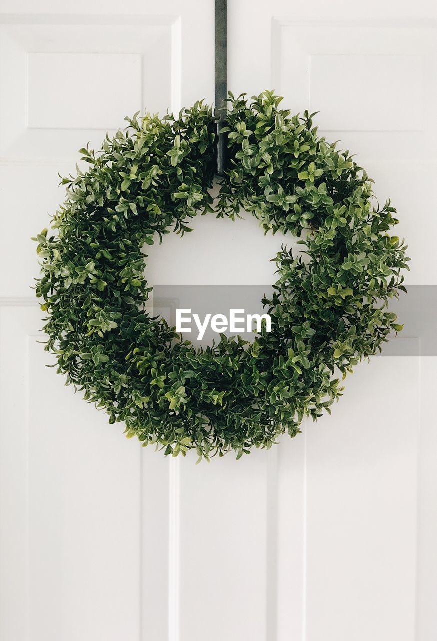 Close-up of wreath hanging on white door