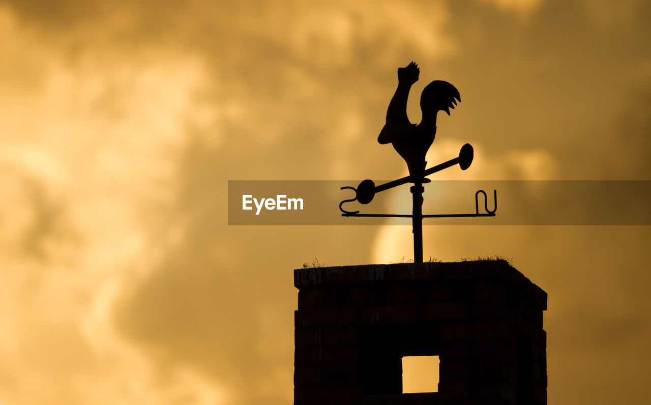 Weather vane at sunset