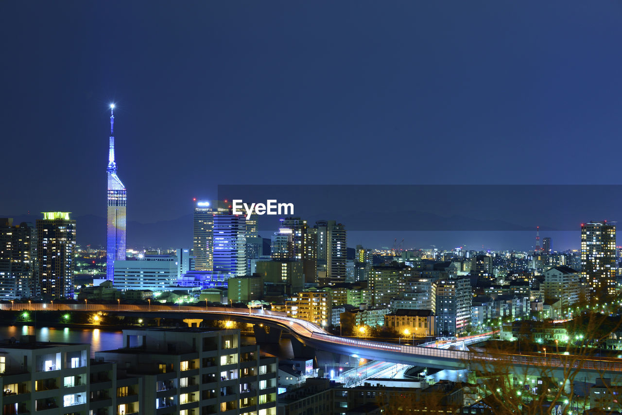 Illuminated buildings in city against sky at night