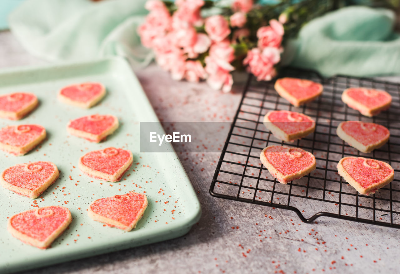 Close up of valentine's day heart cookies cooling on a pan and rack.