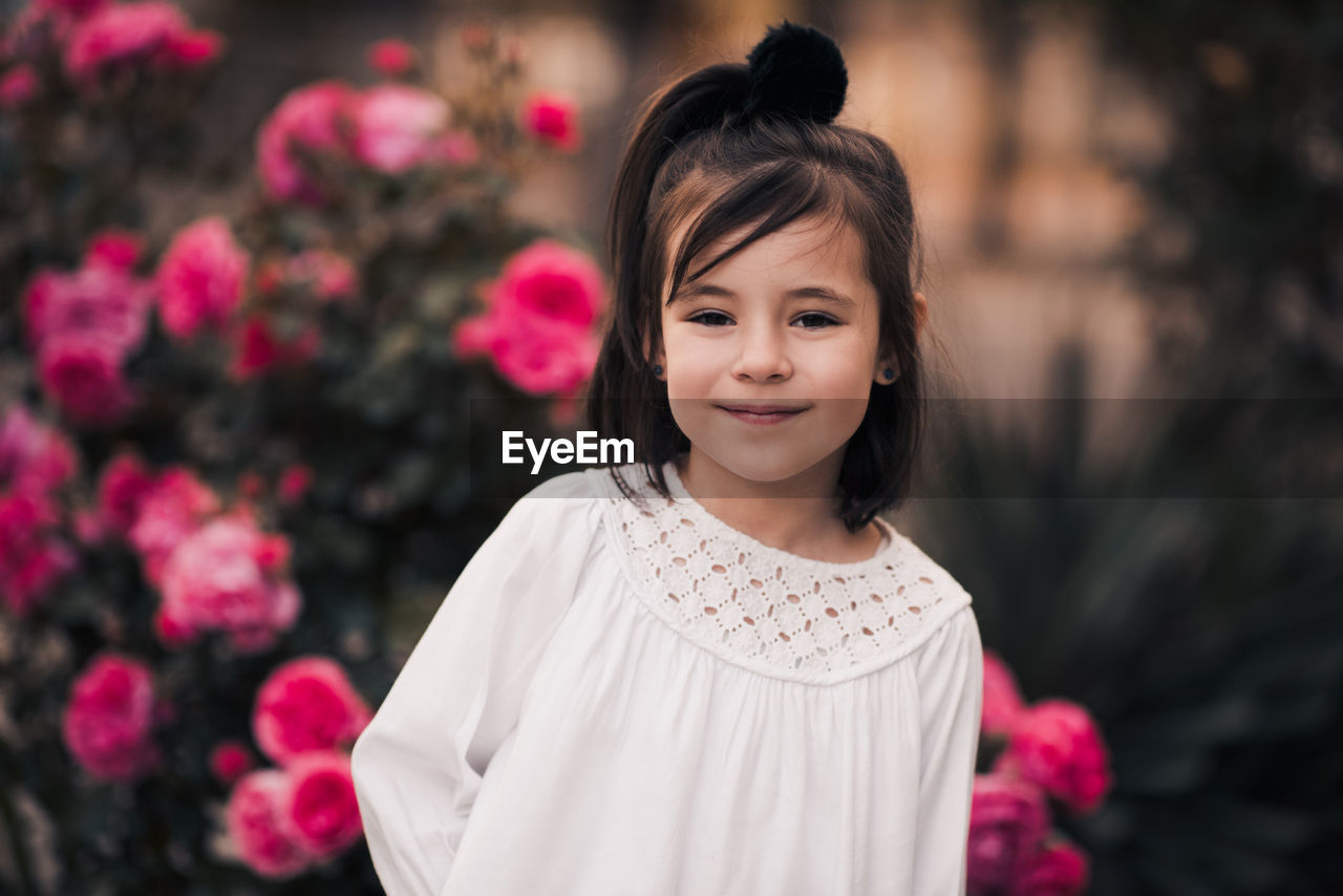 Smiling kid girl 4-5 year old pose over nature background closeup. looking at camera. summer season