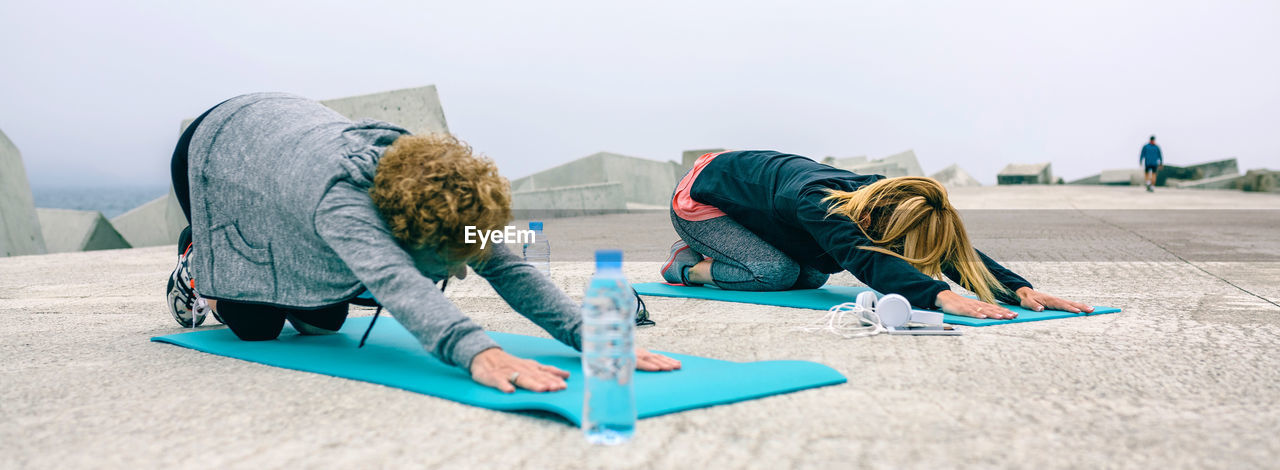 Panoramic view of friends exercising on promenade