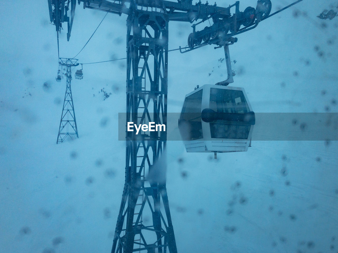 HIGH ANGLE VIEW OF SKI LIFT OVER SNOW COVERED LAND