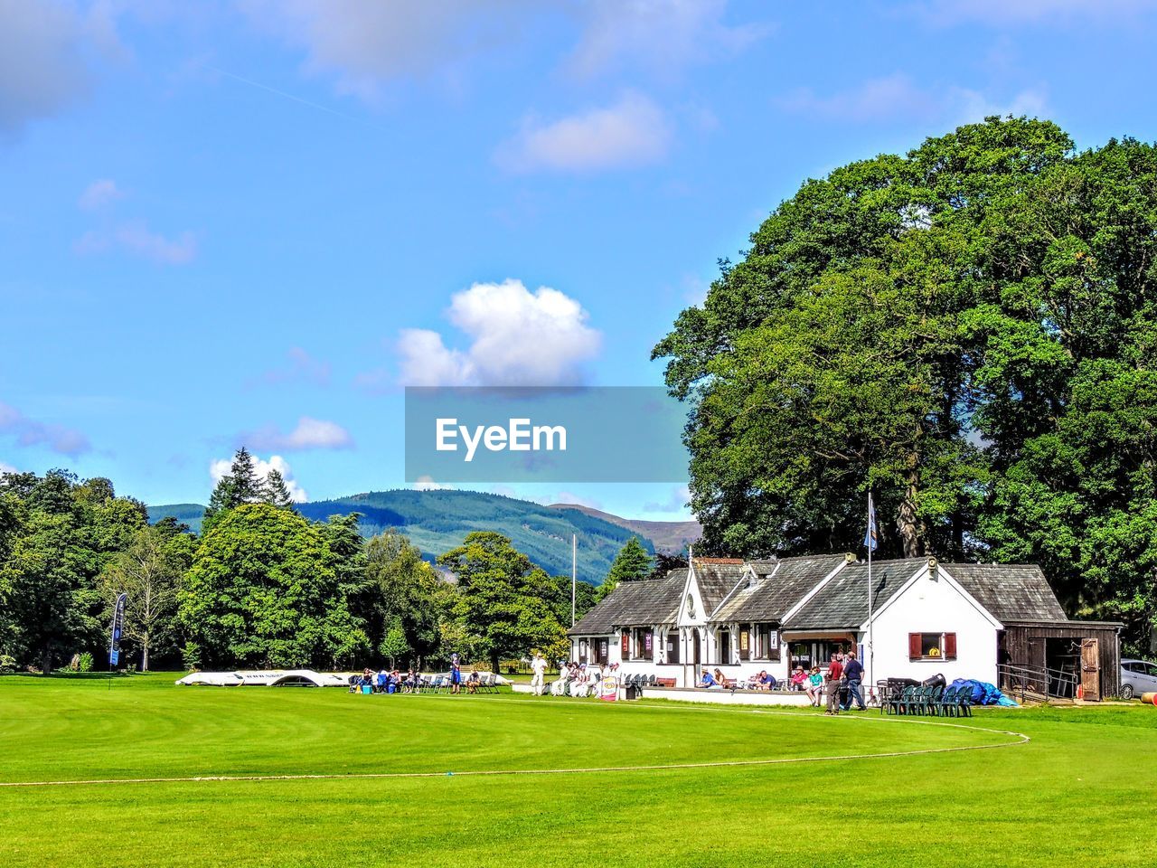 Scenic view of trees and houses against sky