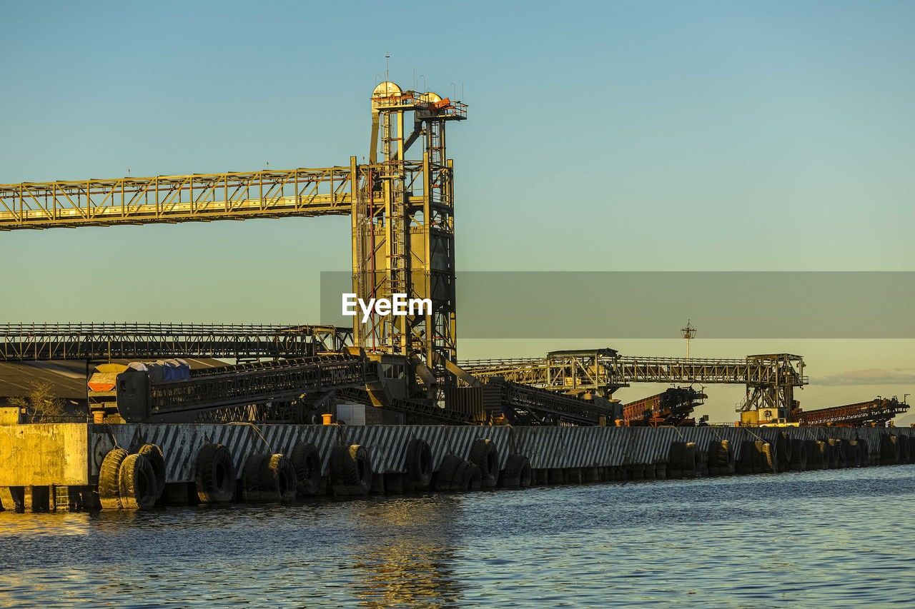 vehicle, water, sky, industry, transport, architecture, built structure, nature, freight transport, machinery, offshore drilling, crane - construction machinery, construction equipment, port, no people, transportation, outdoors, sea, business, clear sky, power generation, business finance and industry
