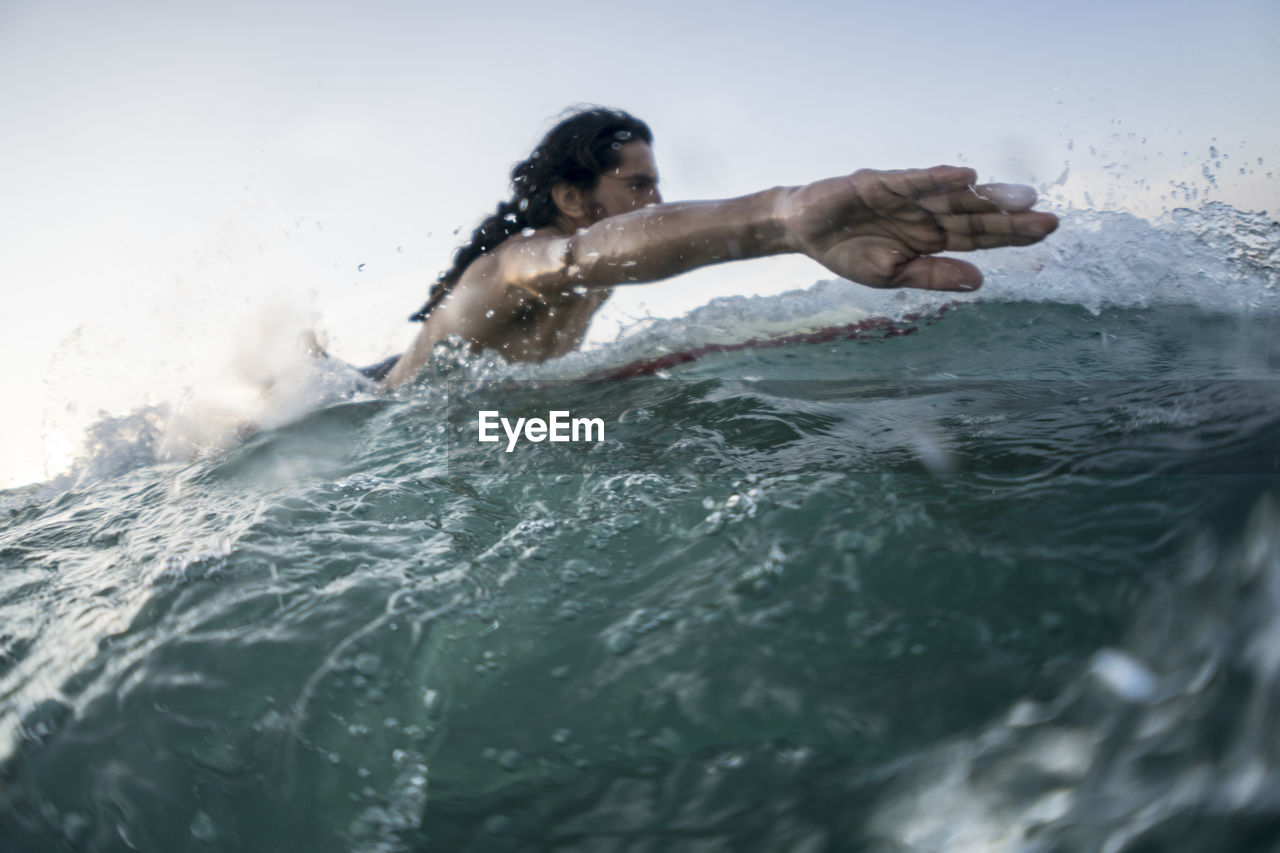 Mid twenties man surfing near punta de mita, mexico