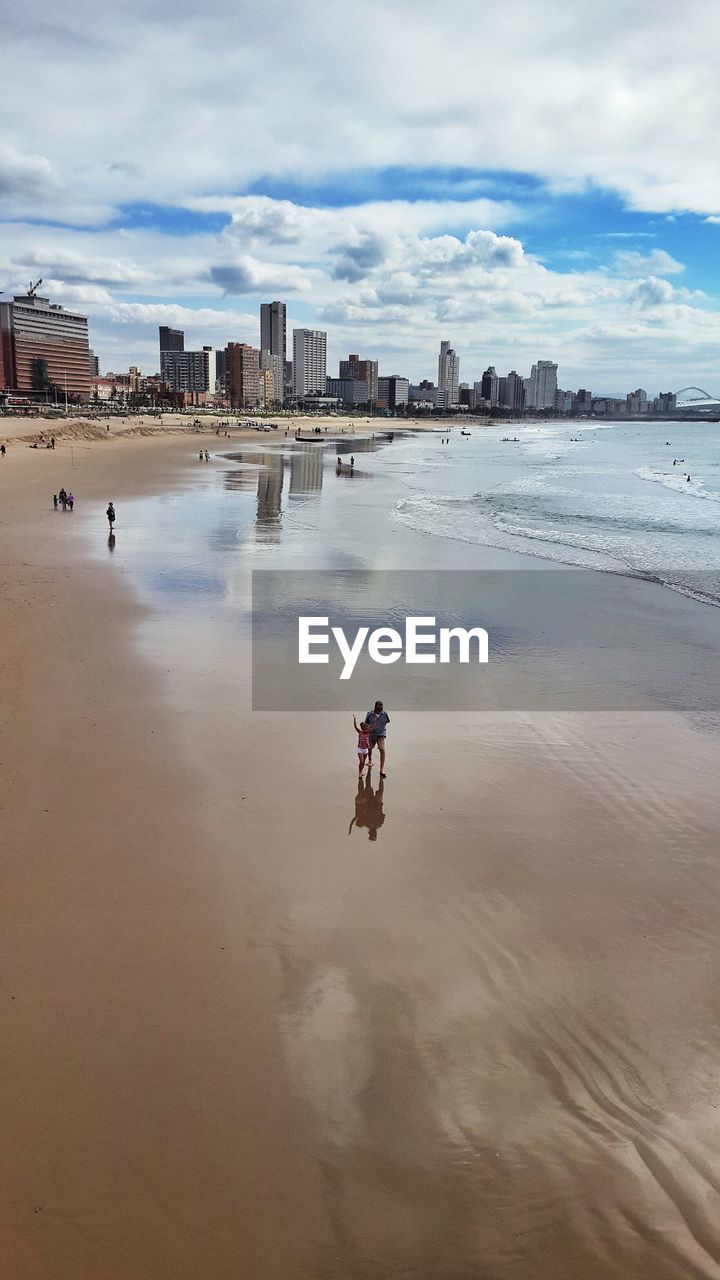 People at beach against sky