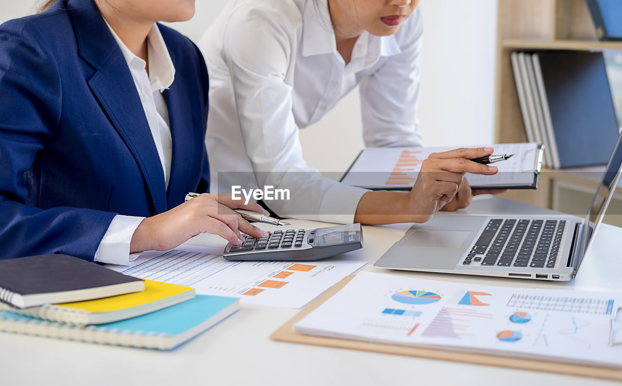 Businesswomen discussing over laptop in office