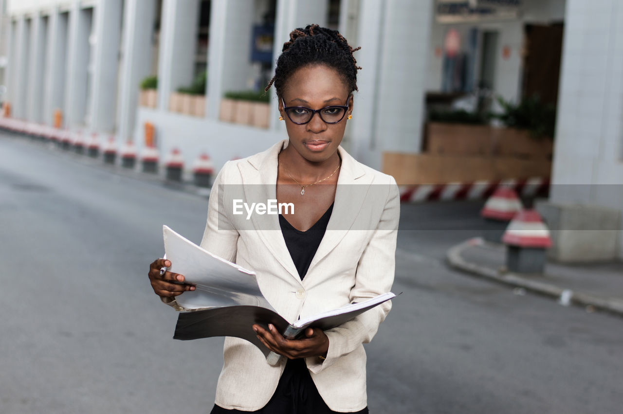 Beautiful young business woman holding a folder containing sales techniques.